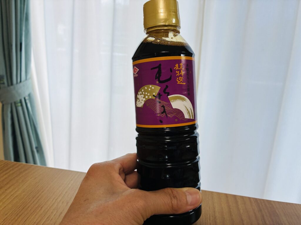 保育士すずが30年愛用しているチョーコー超特選むらさきを手に持っている様子