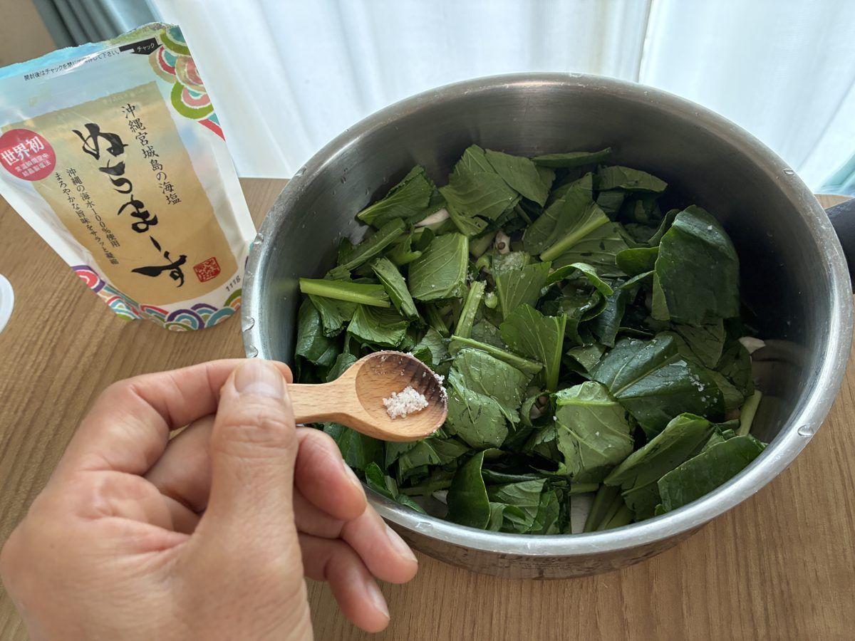 ビタクラフトの深型に小松菜としめじを入れ、塩をひとつまみ入れるところ